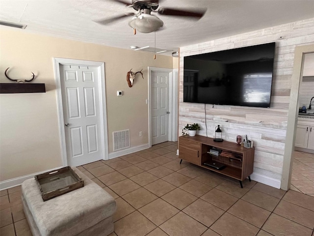 tiled living room featuring ceiling fan