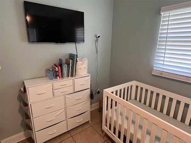 bedroom featuring a nursery area and light tile patterned flooring