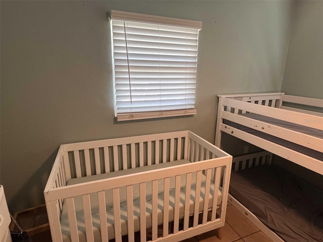 tiled bedroom featuring a crib