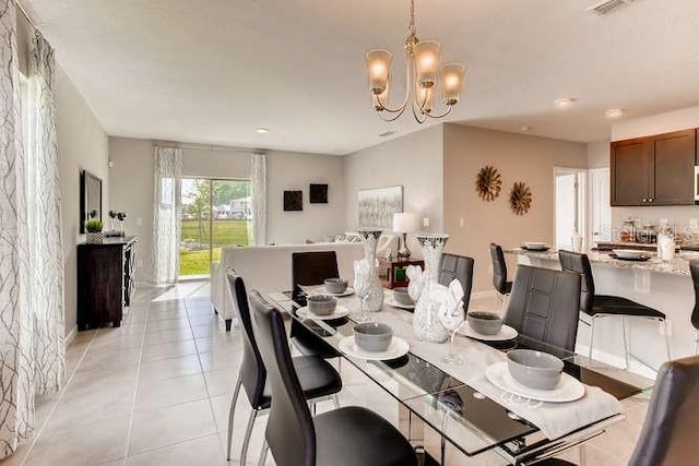 dining space with a chandelier, light tile patterned floors, and visible vents