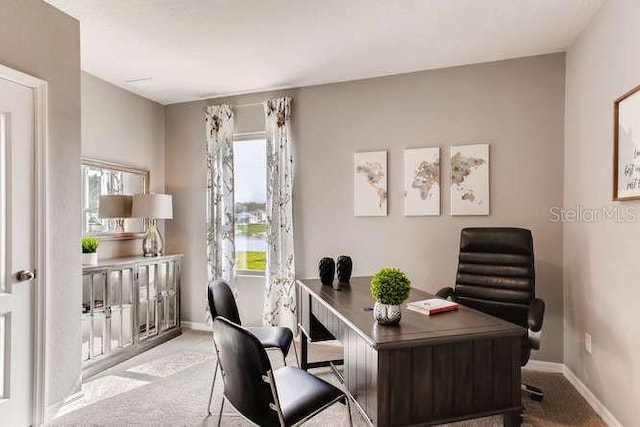 home office with carpet floors, baseboards, and a wealth of natural light