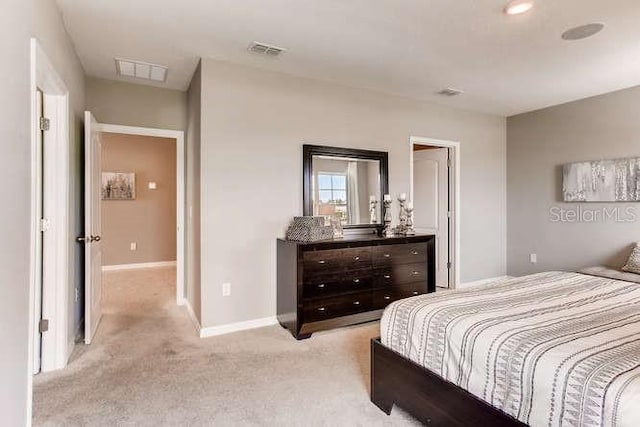 bedroom with light colored carpet, visible vents, and baseboards