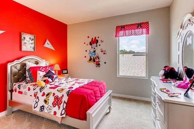 bedroom featuring light carpet and baseboards