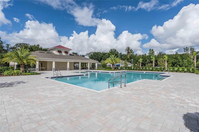 community pool featuring fence and a patio