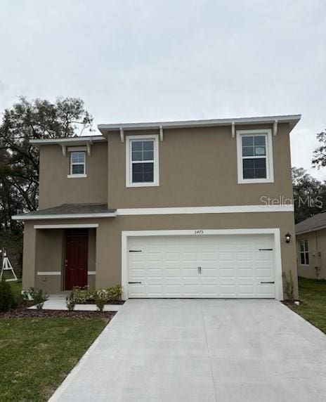 traditional home featuring concrete driveway, an attached garage, and stucco siding