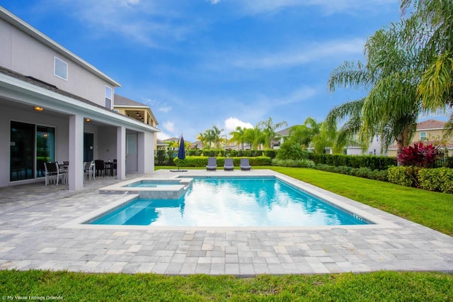 view of swimming pool with a patio, a lawn, and an in ground hot tub