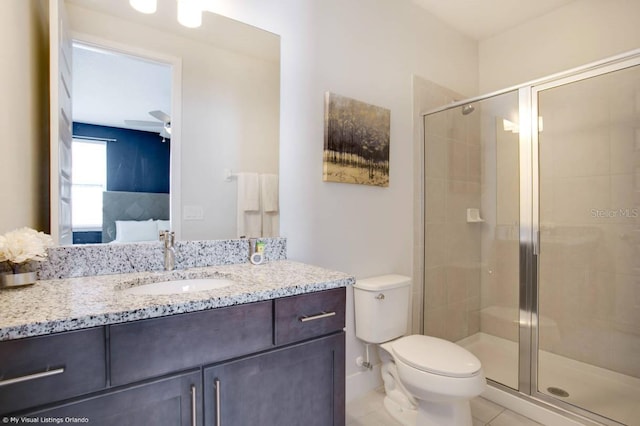 bathroom with walk in shower, vanity, tile patterned floors, and toilet