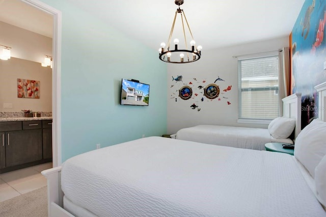 tiled bedroom featuring a notable chandelier and ensuite bath