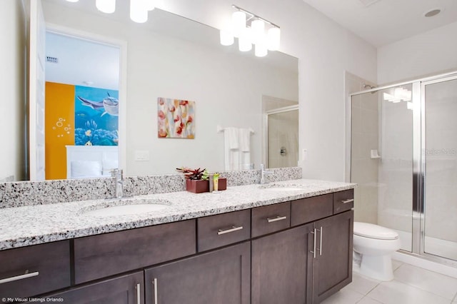 bathroom with vanity, walk in shower, tile patterned floors, and toilet