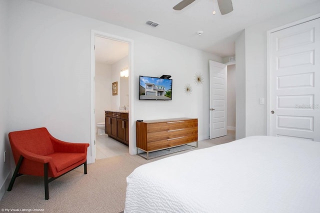 carpeted bedroom featuring ensuite bathroom and ceiling fan