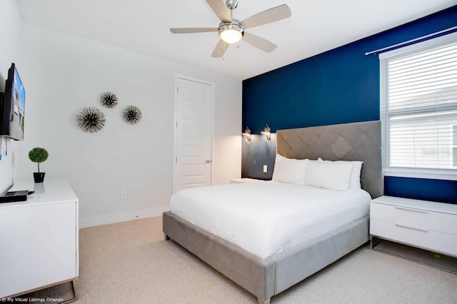 carpeted bedroom with multiple windows and ceiling fan