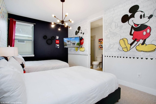 bedroom with ensuite bathroom, an inviting chandelier, and carpet floors