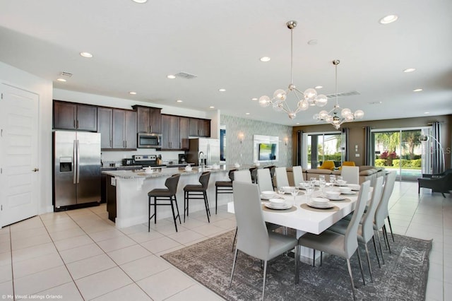 dining room with light tile patterned floors and a notable chandelier