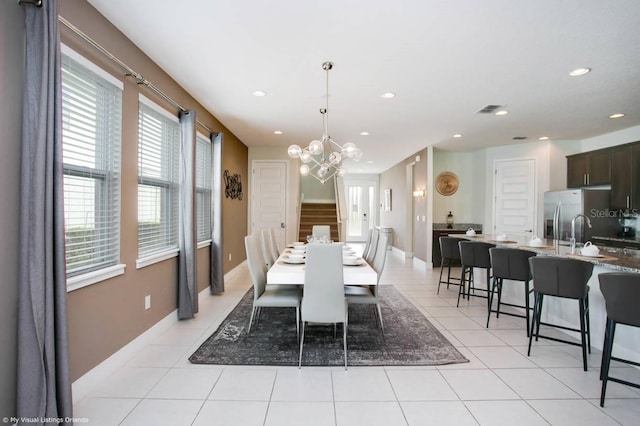 tiled dining room featuring a chandelier and sink