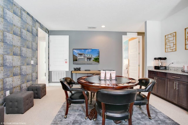 dining room with tile walls and light colored carpet