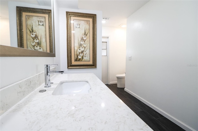 bathroom featuring vanity, toilet, and wood-type flooring