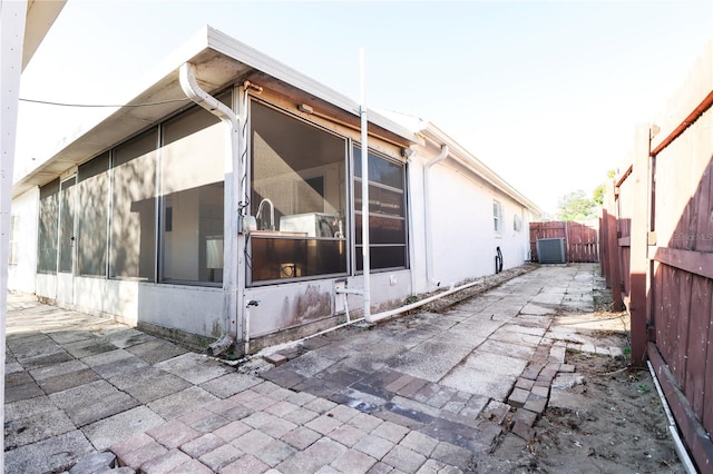 view of property exterior with central AC and a patio