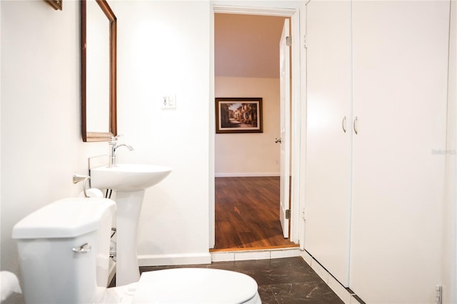 bathroom with hardwood / wood-style floors and toilet