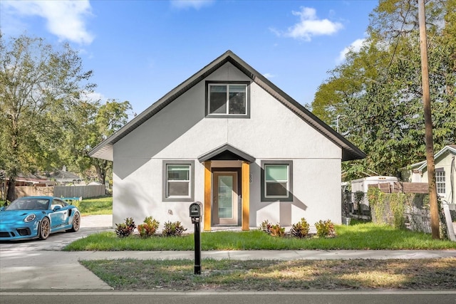 bungalow-style house featuring fence and stucco siding