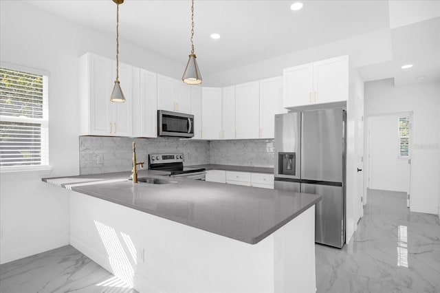 kitchen with decorative backsplash, white cabinets, appliances with stainless steel finishes, a peninsula, and marble finish floor