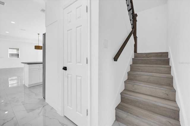 stairway featuring marble finish floor, visible vents, and recessed lighting