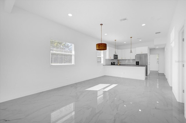 kitchen featuring visible vents, white cabinetry, open floor plan, appliances with stainless steel finishes, and tasteful backsplash