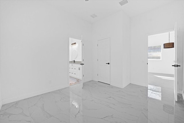 unfurnished bedroom with marble finish floor, visible vents, ensuite bath, and baseboards