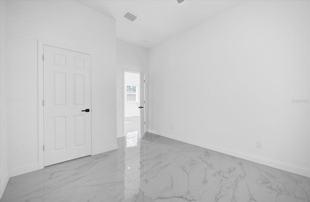 empty room featuring marble finish floor, visible vents, and baseboards