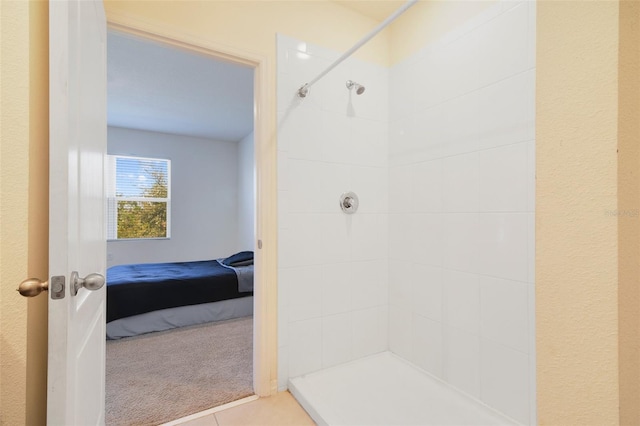 bathroom with tile patterned flooring and a tile shower