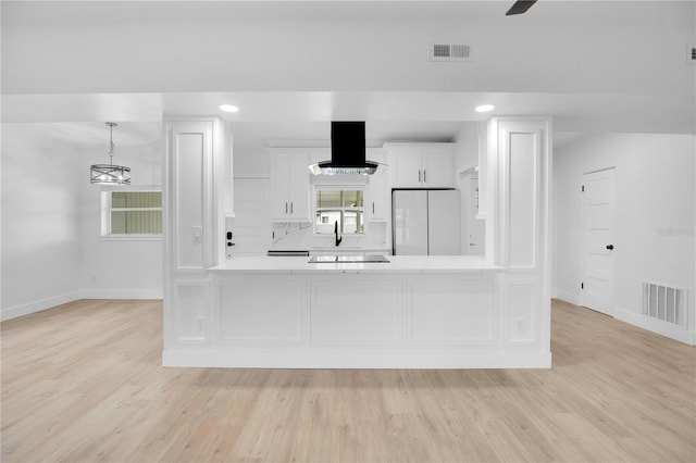 kitchen featuring light hardwood / wood-style flooring, ventilation hood, white fridge, and white cabinets