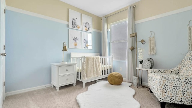 bedroom featuring a nursery area and light colored carpet