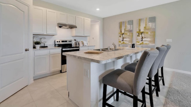 kitchen featuring white cabinetry, stainless steel electric range oven, sink, a kitchen breakfast bar, and a kitchen island with sink