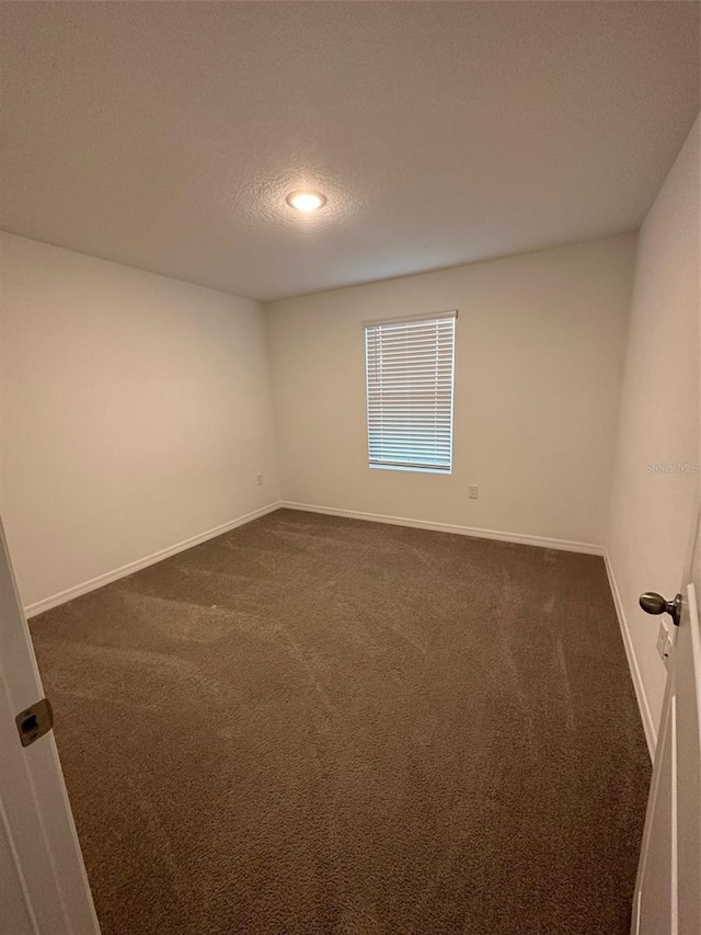 carpeted empty room with a textured ceiling