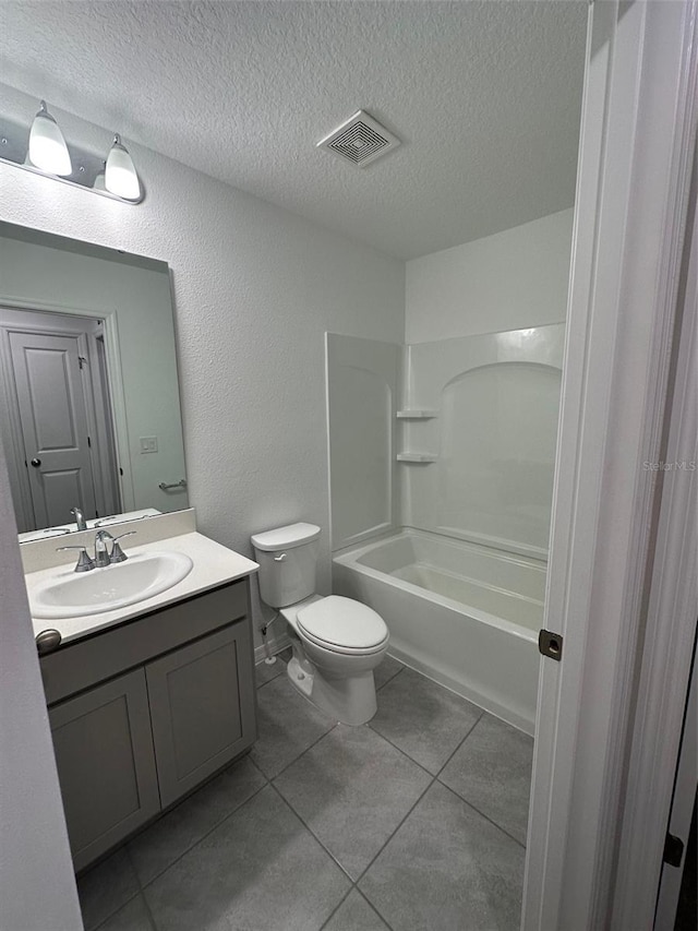 full bathroom featuring vanity, shower / washtub combination, tile patterned flooring, toilet, and a textured ceiling