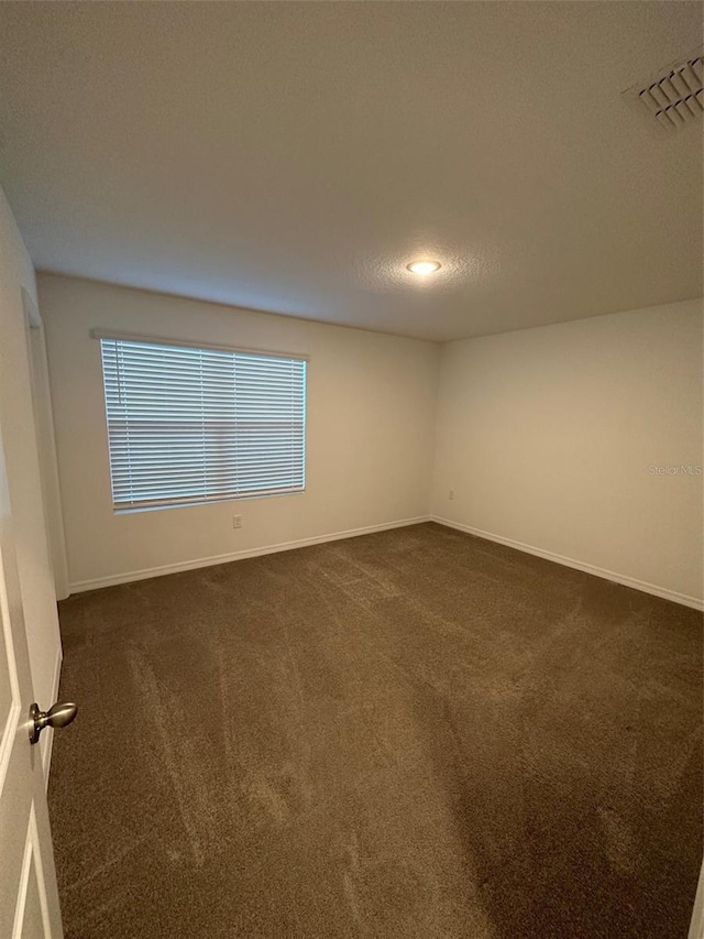 carpeted spare room with a textured ceiling