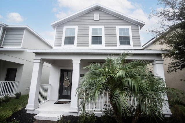 view of exterior entry featuring covered porch