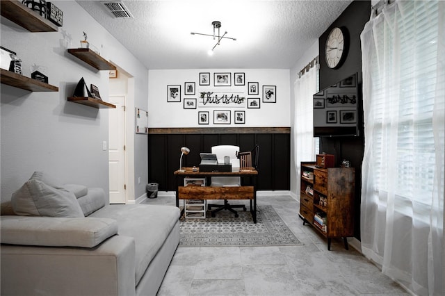 living room featuring a notable chandelier and a textured ceiling