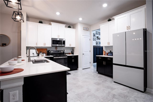 kitchen with white cabinetry, appliances with stainless steel finishes, pendant lighting, sink, and kitchen peninsula