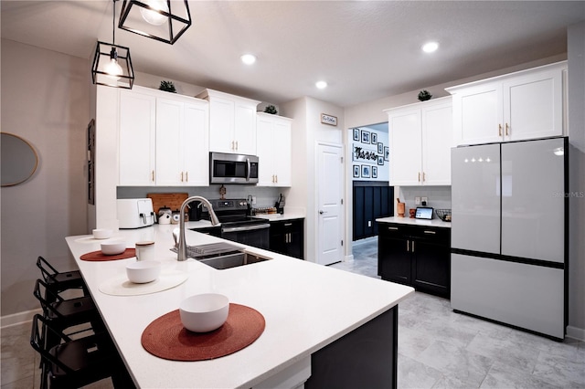 kitchen with stainless steel appliances, pendant lighting, sink, white cabinets, and kitchen peninsula