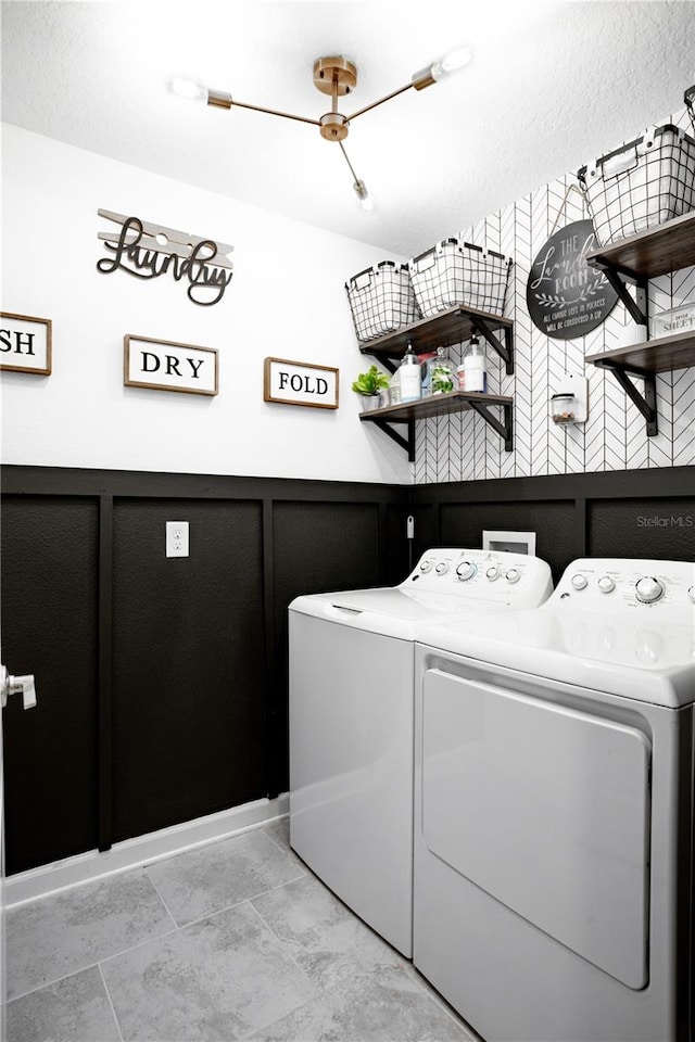 laundry area with light tile patterned floors and washer and clothes dryer