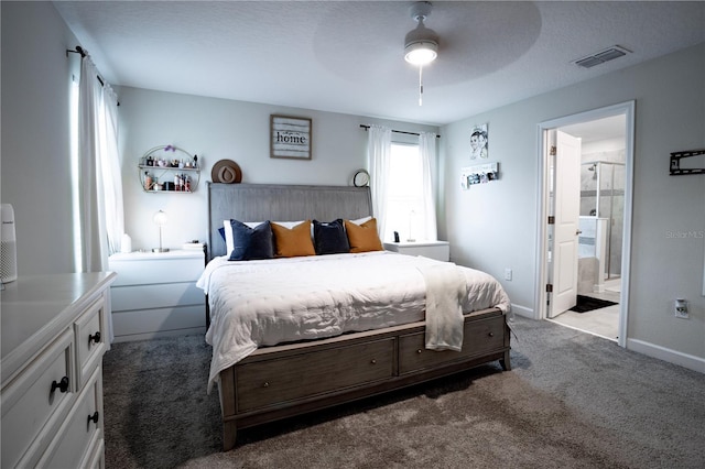 carpeted bedroom featuring a textured ceiling, ensuite bath, and ceiling fan