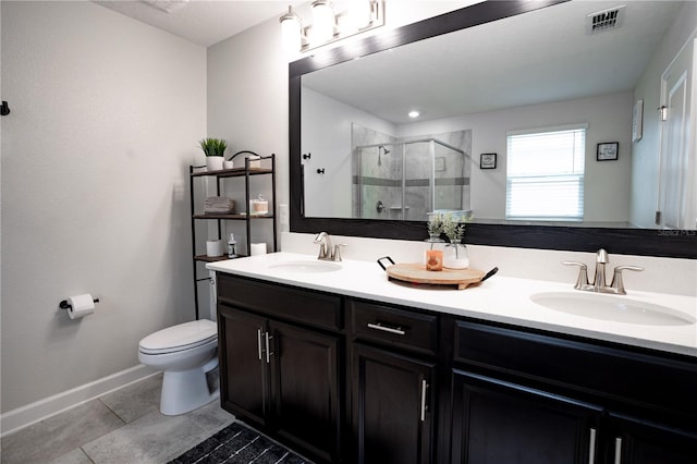 bathroom featuring vanity, a shower with shower door, tile patterned floors, and toilet