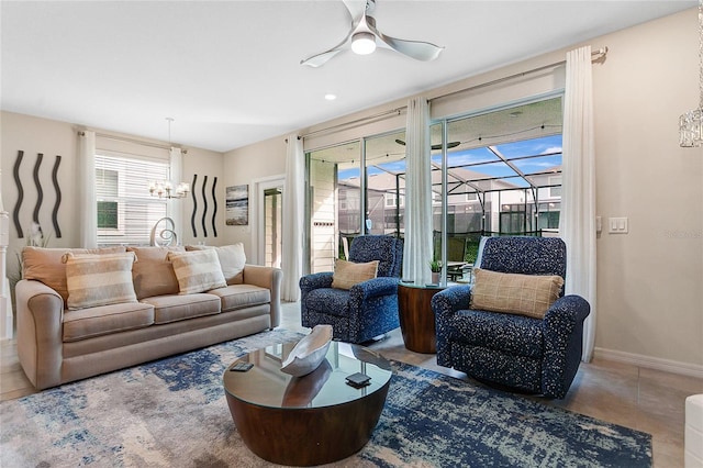 living room featuring ceiling fan with notable chandelier and tile patterned flooring