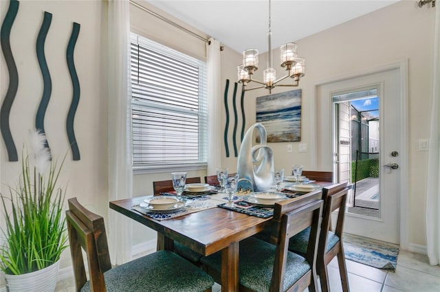 tiled dining room featuring an inviting chandelier