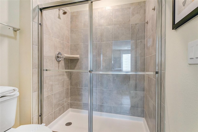 bathroom with toilet and an enclosed shower