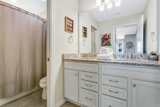 bathroom with vanity, curtained shower, tile patterned floors, and toilet