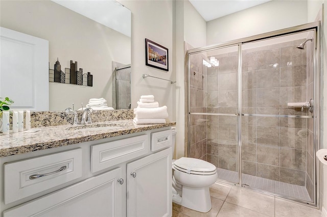 bathroom featuring toilet, an enclosed shower, vanity, and tile patterned floors