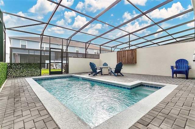 view of pool with a patio and glass enclosure