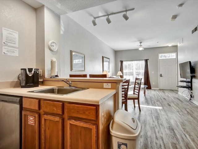 kitchen with track lighting, sink, stainless steel dishwasher, ceiling fan, and light hardwood / wood-style flooring