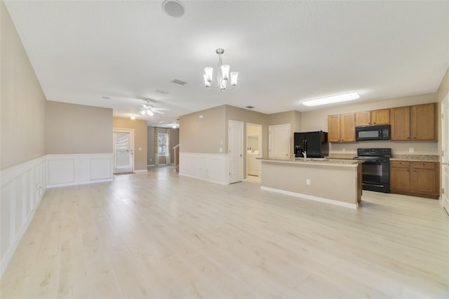 kitchen with ceiling fan with notable chandelier, a center island, black appliances, light wood-type flooring, and decorative light fixtures